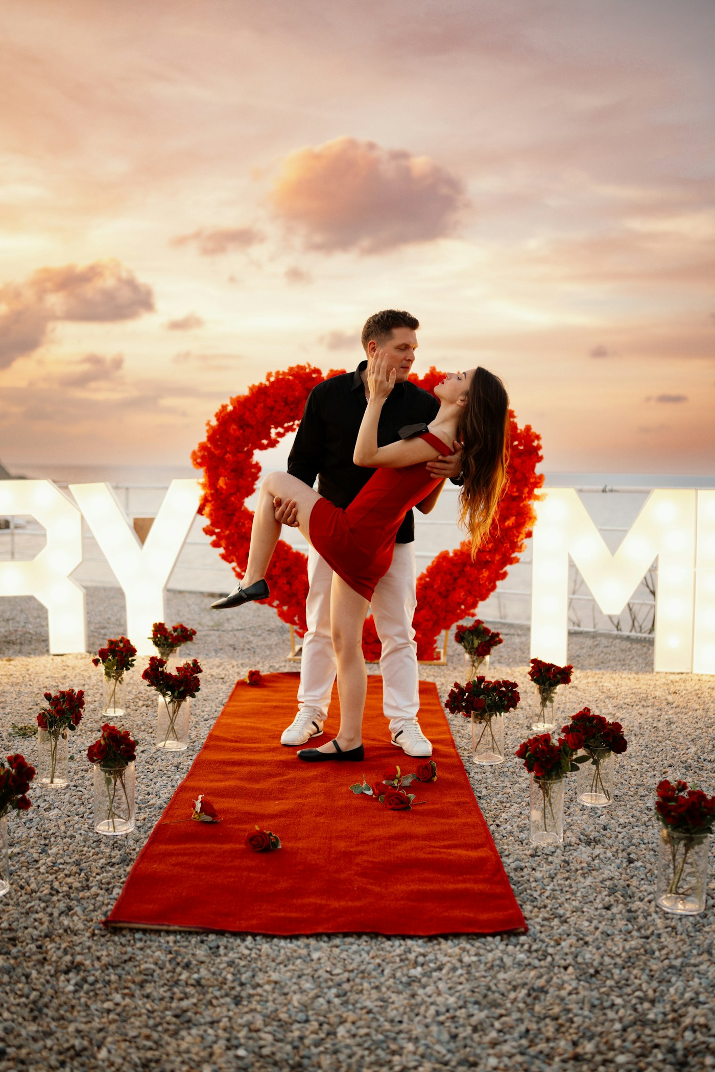 Couple celebrating a proposal on a rose carpet